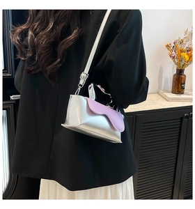 Detail of silver mirror mini crossbody bag with lavender wavy flap on a female model