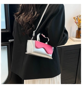 Detail of silver metallic handbag with pink wavy flap and sculpted metal handle
