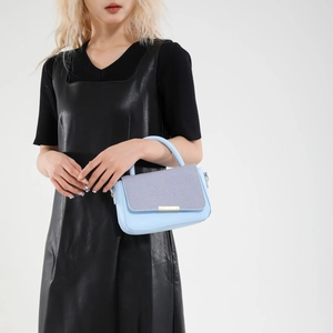 Borsa azzurra con pannello intrecciato grigio e chiusura dorata in vista frontale elegante