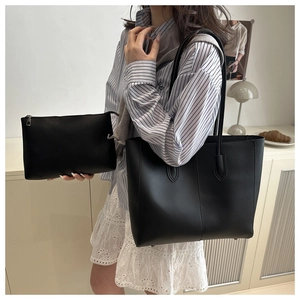 Detail of black tote bag set with a matching pouch and vertical decorative lines