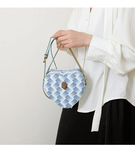 Détail du sac à main en forme de cœur avec motif serpent bleu et fermoir serpent vintage