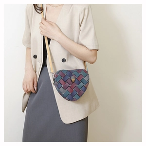 Vue détaillée du sac bandoulière tissé en forme de cœur avec tête d'aigle sur mannequin
