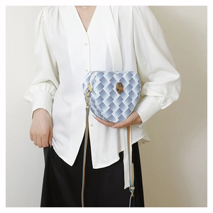 Détail du sac à bandoulière en forme de cœur avec motif zigzag bleu et tête d'aigle dorée