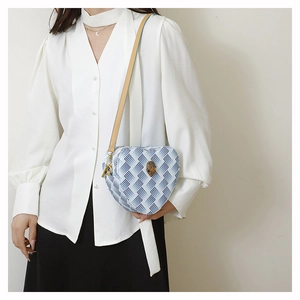 Détail du sac cœur à motif peau de serpent et boucle tête d'aigle dorée vintage