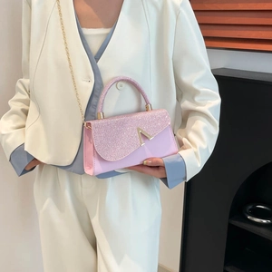 Pink glitter crossbody bag with gold V-metal buckle and chain strap shown on model