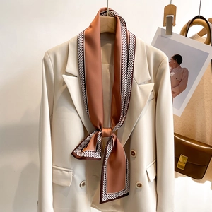 Eleganter brauner Seidenschal mit geometrischem Muster auf einem weißen Zweireiher-Blazer