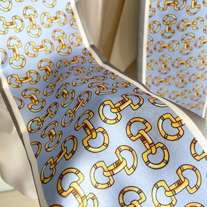 Macro d'un foulard en soie bleu clair avec imprimé mors jaune et blocs de couleurs