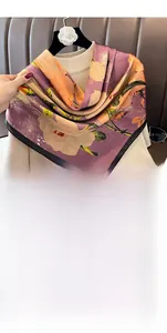 Detail of 90cm faux silk floral scarf in burgundy draped over a beige sweater