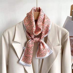 Vue détaillée d'un foulard en satin rose à motifs chaînes sur le revers d'un blazer