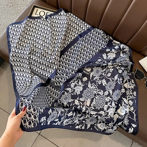 Close-up of double-sided silk scarf featuring navy oblique pattern and floral motif