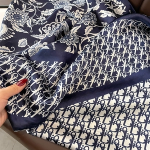 Detail of double-sided silk scarf with floral pattern and monogram print texture