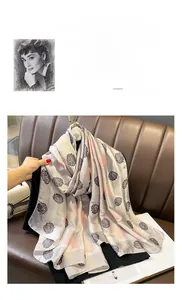 Dettaglio di elegante sciarpa in seta beige con motivo a camelia e finitura satinata