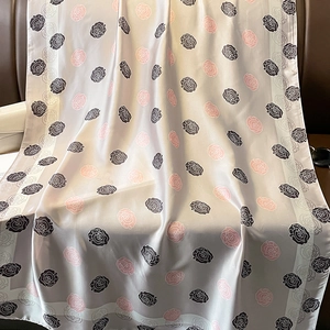 Elegante sciarpa in seta grigio argento con rose rosa e nere su sedia di pelle