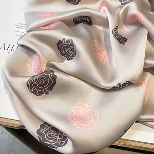 Elegante sciarpa in raso grigio perla con motivi di rose rosa, trama morbida e setosa