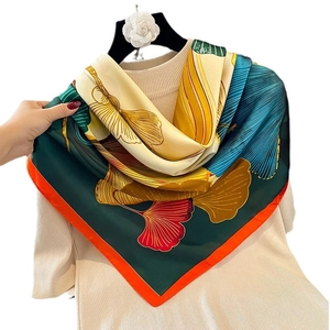 Silk-like satin scarf featuring colorful ginkgo leaf patterns and orange border accents