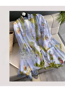 Détail d'un foulard en soie à imprimé floral drapé avec élégance sur un canapé