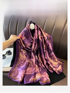 Detail of silk-like purple scarf featuring elegant rose prints and gold chain patterns