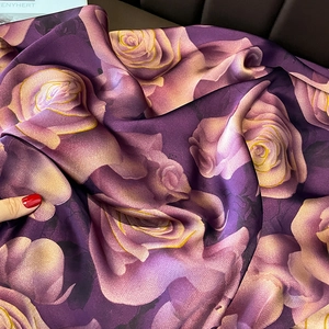 Close-up of purple silk scarf with golden rose patterns showing soft fabric texture