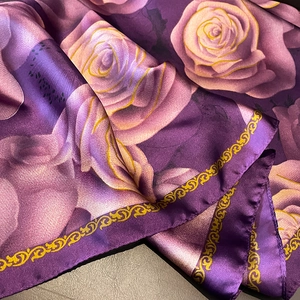 Close-up of silk scarf showing purple rose prints and vintage golden scroll borders