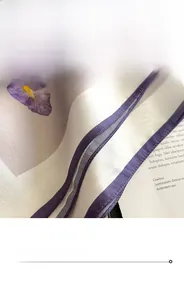Detailed close-up of fine purple stitching on a high-quality silk square scarf