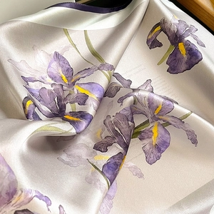 Close-up of silk square scarf featuring purple iris prints and rolled edges