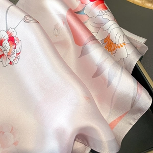 Gros plan d'un foulard en soie à imprimé floral de pivoines et texture satinée