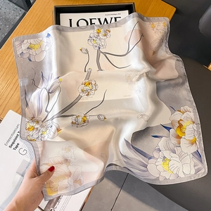 Carré de soie élégant à imprimé floral et bordures grises sur un magazine de mode