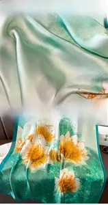 Detail view of large white lily print on green faux silk scarf with high-quality hemmed edges