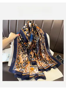 Detail of oversized navy silk scarf with vintage floral patterns held to show drape