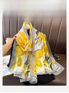 Detail view of long silk scarf with yellow floral pattern on elegant grey border