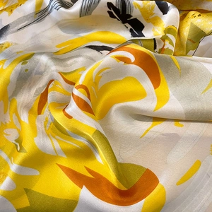 Elegant floral silk shawl featuring vibrant yellow and orange abstract artistic patterns