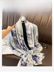 Detail of light blue floral oversized silk scarf with smooth glossy finish on hanger