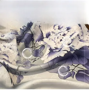 Detail of soft silk-like fabric with peony flower prints in purple and blue tones