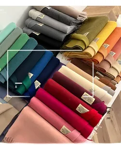 Close-up of double-sided cashmere-like scarves in multiple colors with tassel details