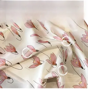 Detail of elegant imitation silk scarf with soft pink floral patterns and glossy texture