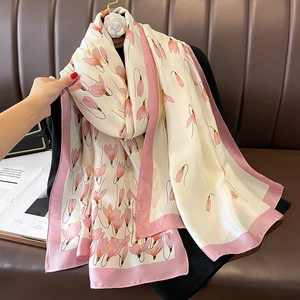 Elegant beige silk scarf with pink tulip floral print and satin border on a hanger