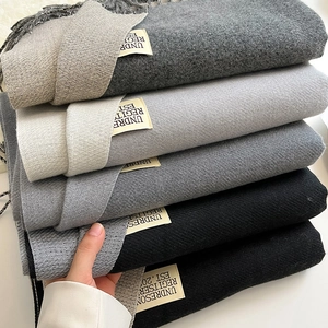 Detail of multi-color cashmere scarves with tassel edges and brand label on fabric