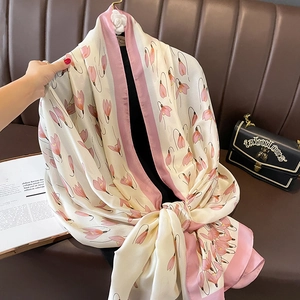 Elegant lightweight silk-like scarf with pink tulip floral print for women on a sofa