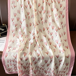 Elegant silk scarf with pink tulip floral patterns and soft borders on leather background