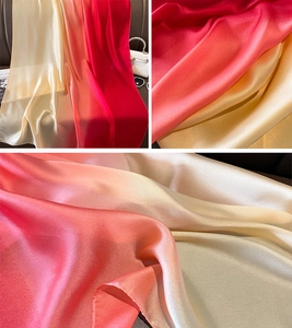 Detail view of the gradient silk scarf showing soft cream to dark red satin fabric texture