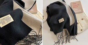 Detail of soft cashmere-like scarf showing twill texture, fringe, and a minimalist brand label
