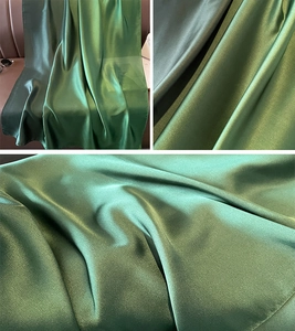 Detail of dark green satin scarf with smooth silk texture and metallic luster display