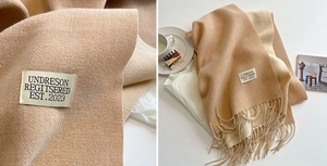 Macro detail of camel cashmere-feel scarf featuring herringbone weave and tassel edges
