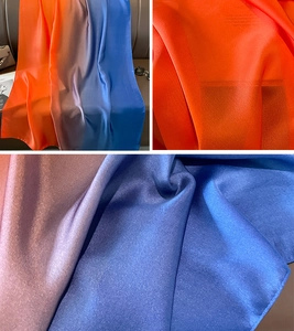 Detail of gradient satin silk scarf showing vibrant orange to royal blue color transition