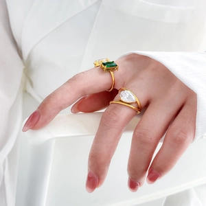 Détail de bagues double couche plaquées or 18K avec zircons verts et en forme de poire