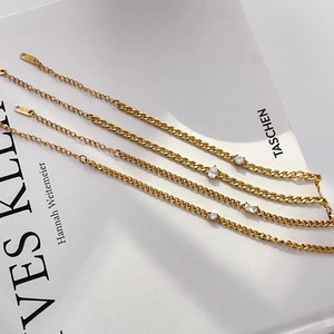 Detail of 18K gold-plated stainless steel bracelets with zirconia charms and K18 hallmark