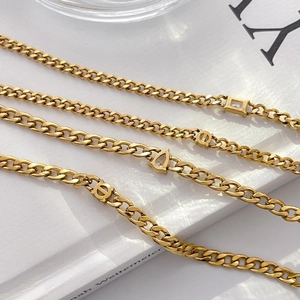 Macro detail of 18K gold plated chain bracelets with teardrop and square zircon stones
