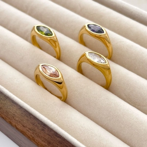 Gros plan de bagues serties de pierres marquises en vert, violet, blanc et or champagne