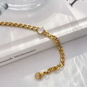 Close-up of 18K gold plated steel chain bracelet with a teardrop zircon accent