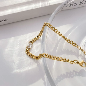 Detailed macro view of 18K gold plated chain featuring a baguette-cut cubic zirconia